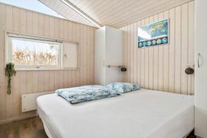 a bedroom with a white bed in a room with a window at 1627-Dronningmolle-Svalevej-3 in Dronningmølle