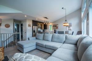 a living room with a large couch and a kitchen at LAKE and SPA - Le Matit 21 in Saint Come