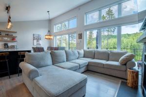 a living room with a large couch and windows at LAKE and SPA - Le Matit 21 in Saint Come