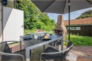 a table and chairs with an umbrella on a patio at Ferienanlage Bansin Seepferdchen 1 in Bansin