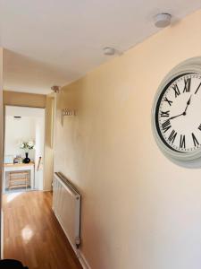 a large clock on the wall of a room at Dolmans Retreat in Lytchett Matravers