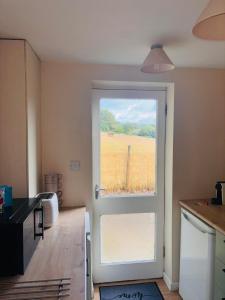 a kitchen with a door with a view of a field at Dolmans Retreat in Lytchett Matravers
