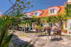 Un grupo de mesas y sillas frente a un edificio. en Casa do Patio by Shiadu, en Lisboa 35 fotos más