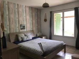 a bedroom with a bed and a window at Maison belle-vie in Corconne