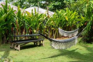 a hammock and a bench in a garden at FOREVER SIARGAO in General Luna