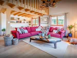 a living room with pink couches and a coffee table at Chalet Joux Verte - OVO Network in Les Gets
