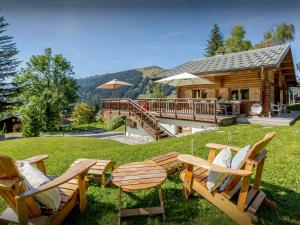 a group of chairs and tables in front of a log cabin at Chalet Joux Verte - OVO Network in Les Gets