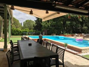 a patio with a table and a swimming pool at Maison belle-vie in Corconne +5 photos