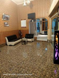 a living room with two couches and a television at Peace Hotel Fizagat, Swat in Mingora