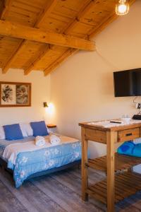 ビージャ・ペウエニアにあるSUOMIのベッドとテレビ付きの机のある寝室 +21枚の写真