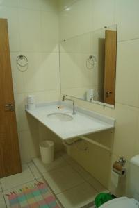 Un baño con lavabo, espejo e inodoro. en Ipê Rosa Hotel, en Bauru 57 fotos más