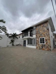 a large white house with a large driveway at Tema Suites in Tema