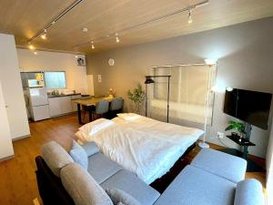 a bedroom with a bed and a couch and a table at Shibamata house self check in in Tokyo