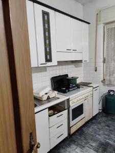 a kitchen with white cabinets and a stove top oven at WatganVentHouse in Gli Angeli