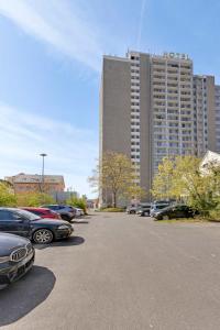 a large building with cars parked in a parking lot at MONTAGO Monteur-Apartmenthaus Frankfurt Airport in Neu Isenburg