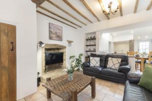 a living room with a couch and a fireplace at Charming 3-Bed Cottage in Central Stroud in Gloucestershire