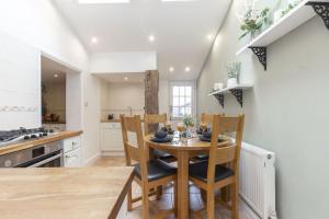 a kitchen with a wooden table and chairs in a room at Charming 3-Bed Cottage in Central Stroud in Gloucestershire