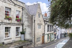 an old building with flowers in windows on a street at Charming 3-Bed Cottage in Central Stroud in Gloucestershire +43 photos