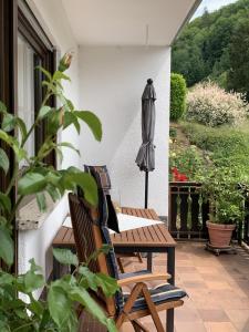 a patio with two chairs and a table and an umbrella at Ferienwohnung Meyerhöfer in EuÃŸerthal