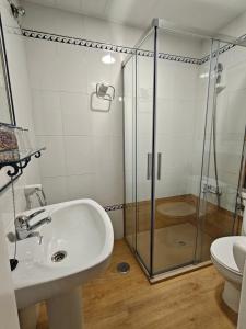 ein Badezimmer mit Waschbecken und Glasdusche in der Unterkunft Alojamiento la Casa del Brigadier in Cerro Muriano + 4 Fotos