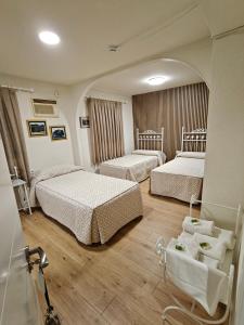 ein Hotelzimmer mit zwei Betten und einem Spiegel in der Unterkunft Alojamiento la Casa del Brigadier in Cerro Muriano