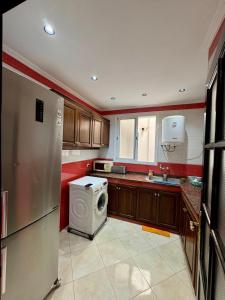 a kitchen with a refrigerator and a washing machine at Apartment oasis moderne in Tangier
