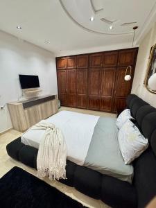 a bedroom with a large bed with wooden cabinets at Apartment oasis moderne in Tangier