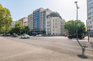 Una calle con coches circulando por una calle con un edificio. en GuestReady - Elias Garcia Apartments, en Lisboa