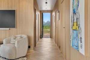 Un pasillo con una silla y un televisor de pantalla plana. en New designer cabin in Lofoten, en Storøya