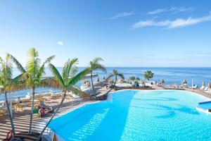 una piscina con el océano al fondo en Servatur Riosol, en Puerto Rico de Gran Canaria