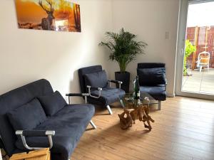 een woonkamer met 2 stoelen en een bank bij Rebe 11 - Moderne Ferienwohnung mit Sauna in Oestrich-Winkel