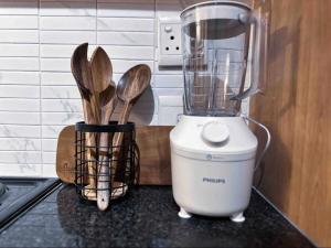 a blender sitting on top of a counter with wooden spoons at Luxurious 2 bedroom Apartment! in Centurion +9 photos