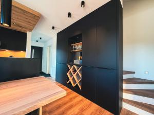 フィッシェン・イム・アルゴイにあるACHZEIT Family Retreat - Alpin-modernes Ferienhaus - 3 SZ - Garten - Kaminのキッチン(黒いキャビネット、木製テーブル付)