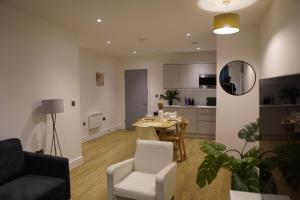 a living room with a table and chairs and a kitchen at Stylish & Cozy 1bed apartment in city centre in Birmingham