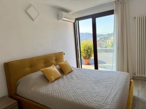 Un dormitorio con una cama con una ventana grande. en Villa Catocce - Beautiful New Apartments with Parking - by HOST4U, en Imperia