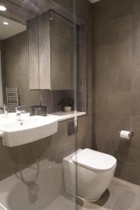 a bathroom with a white toilet and a sink at Stylish & Cozy 1bed apartment in city centre in Birmingham +31 photos