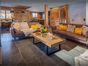 ein Wohnzimmer mit Sofas und einem Couchtisch in der Unterkunft Chalet Angelia - OVO Network in Le Grand-Bornand