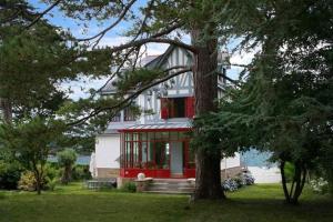 a red and white house with a tree at Villa Ty Marie Ile aux Moines sur la plage vue mer à 180 dégrés in Ile aux Moines