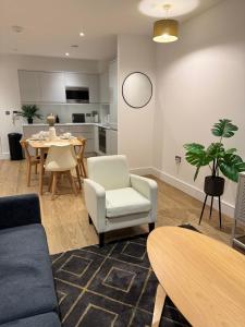 a living room with a couch and a table and chairs at Stylish & Cozy 1bed apartment in city centre in Birmingham