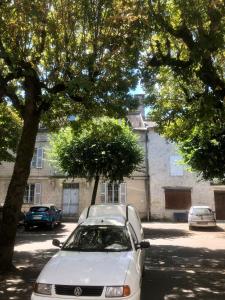 a white car parked in front of a building at Appartement minimaliste et cozy in Cajarc +3 photos