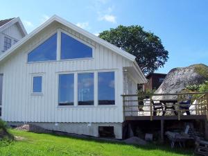 a white house with a large window on the side of it at 4 person holiday home in HENÅN-By Traum in Henån