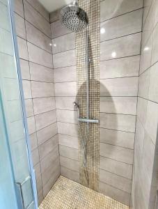 une douche avec pommeau de douche dans une salle de bain dans l'établissement Appartement tout équipé avec terrasse à 600m du centre thermal, à Lamalou-les-Bains