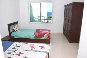 a bedroom with two twin beds and a window at Marrakech Style Seaside Escape in Kelibia