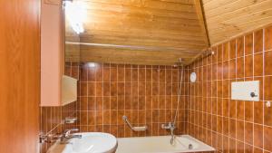 a bathroom with a sink and a bath tub at Chesa Sarvit 5 - Celerina in Celerina +22 photos