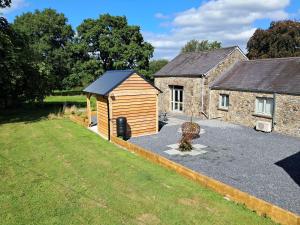 a small wooden shed next to a building at Dinefwr Cottage in Carmarthen
