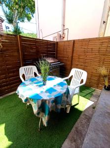 - une table et des chaises sur une terrasse avec barbecue dans l'établissement Appartement tout équipé avec terrasse à 600m du centre thermal, à Lamalou-les-Bains