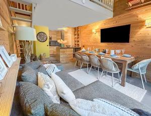 a living room with a long couch and a table at Appartement T3 cosy sur les pistes avec parking in Le Grand-Bornand