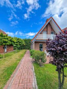 a brick house with a brick pathway in front of it at Gretel in Greetsiel