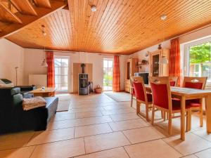 a living room with a wooden ceiling and a table and chairs at Gretel in Greetsiel