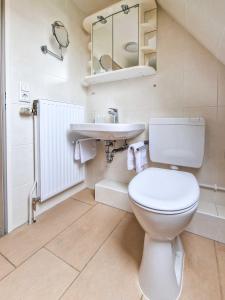 a white bathroom with a toilet and a sink at Gretel in Greetsiel +33 photos